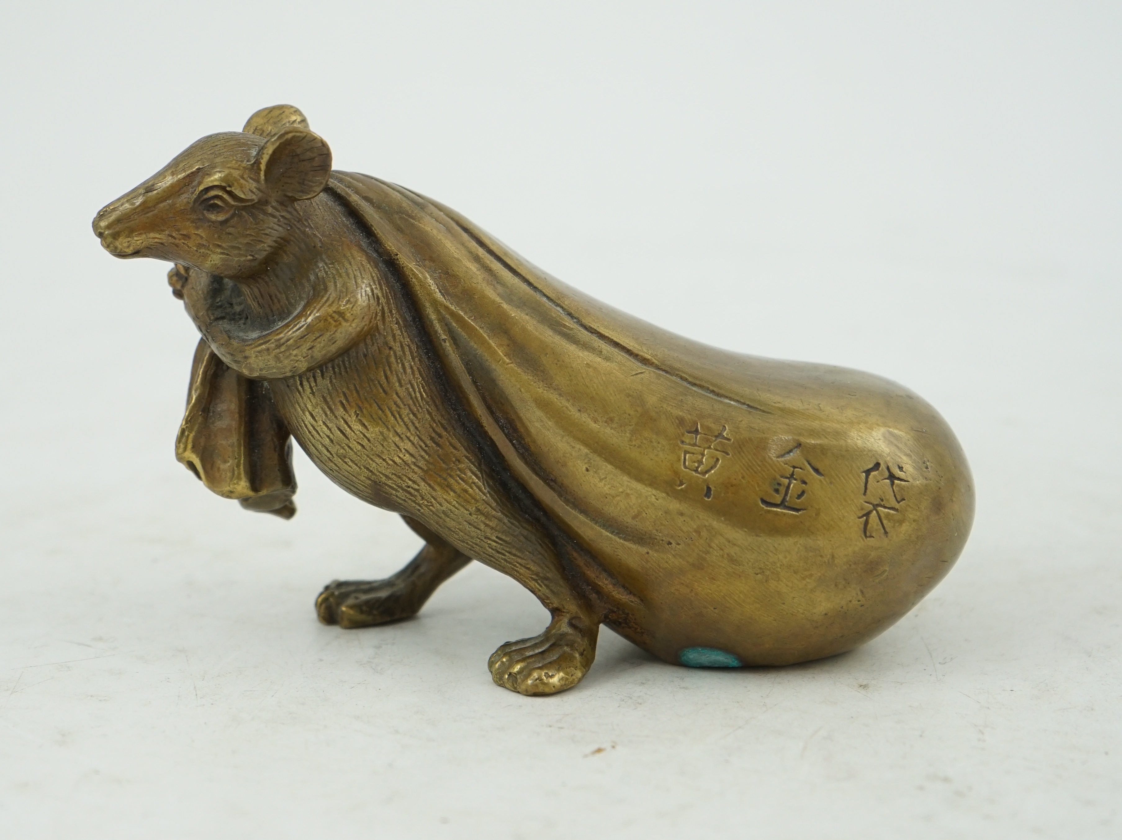 A Chinese bronze rat carrying a sack, signed in casting, 14cm long. Condition - fair